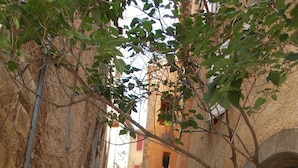 A narrow alleyway with stone walls, a red door, and a staircase leading to a building. - Nice little studio 20 M2 (AUPS)