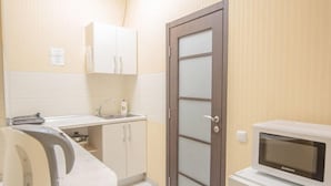 A small kitchenette with a microwave, a kettle, and a sink. - Flatsis Apartment Kuznechnaya 13 (Kharkiv)