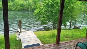 Eine Holzterrasse mit Blick auf Fluss und Wald.