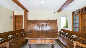 A traditional dining room with a long wooden table and benches. - Super OYO 890 Dewi Fortuna Guest House (Depok)