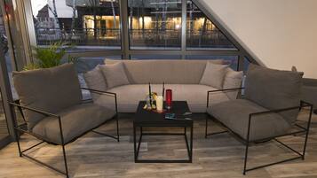 Ein modernes Wohnzimmer mit einer Couch, zwei Sesseln und einem Couchtisch.