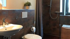 A modern bathroom with a sink, toilet, and shower. - Pension Schell (Dossenheim)