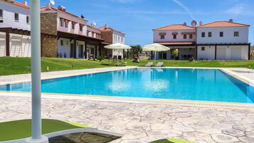 Een buitenzwembad en ligstoelen