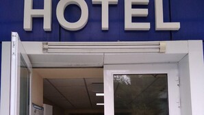 Hotellin sisäänkäynti, jonka yläpuolella olevassa suuressa kyltissä lukee ”HOTEL”.