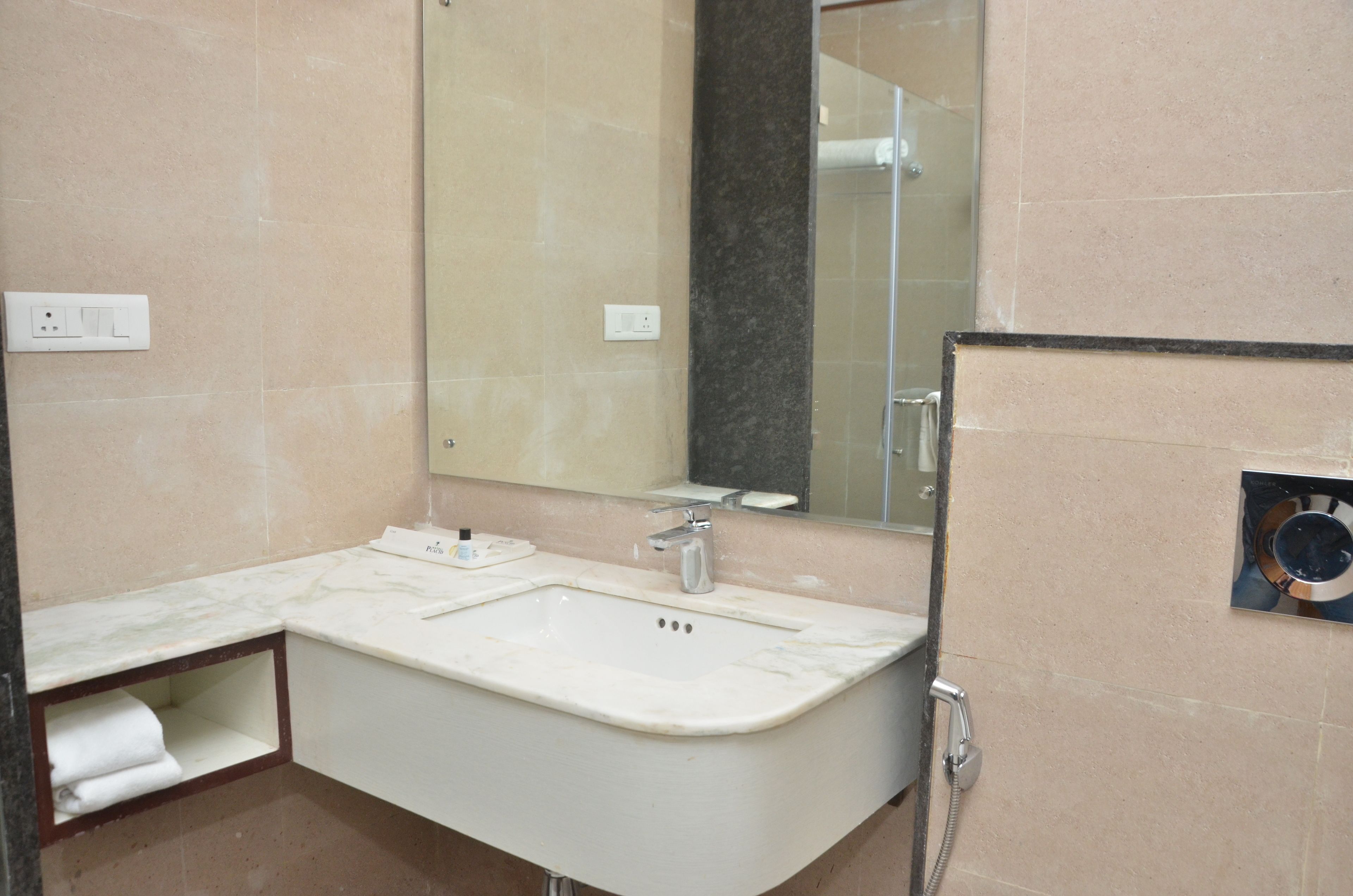 Un baño con lavamanos, espejo y ducha.