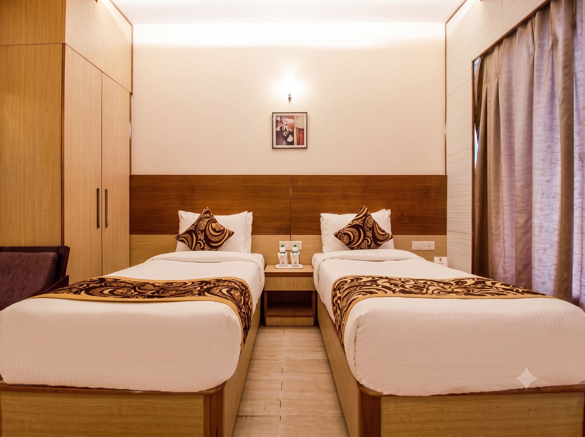 A hotel room with two beds, wooden headboards, a nightstand with toiletries, and a framed picture on the wall.