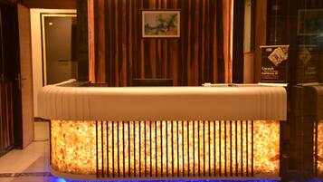 Una reception con una base illuminata e un quadro appeso sopra.
