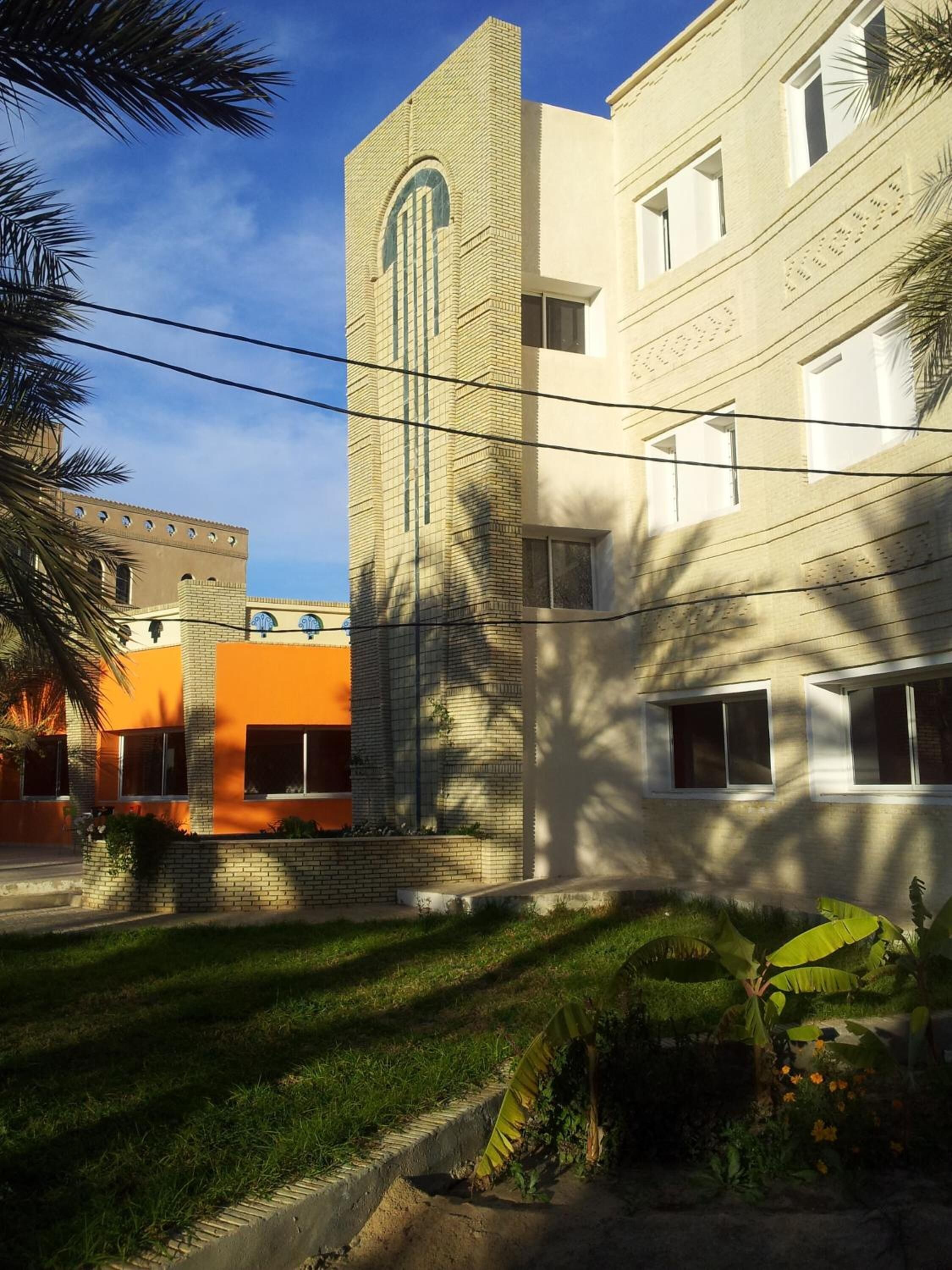 Un edificio a più piani con una torre centrale e un'ampia finestra ad arco.