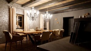Un comedor con una mesa de madera, sillas y una araña.