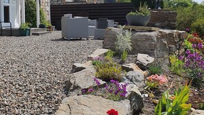 A stone building with a garden area featuring a variety of plants and flowers. - Beautiful views, walking distance to town (Pitlochry)
