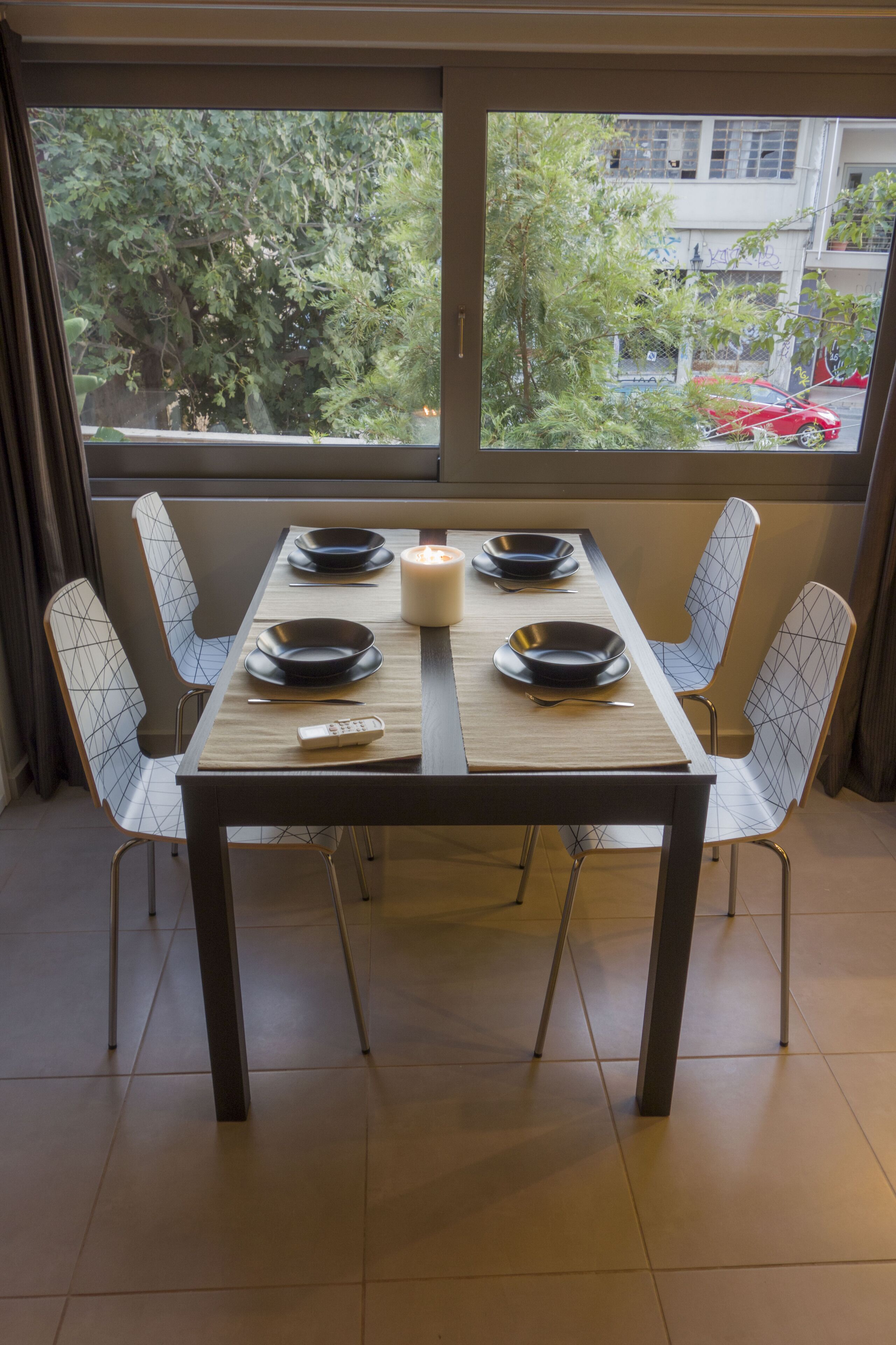 A dining table set with plates, a candle, and a remote control.