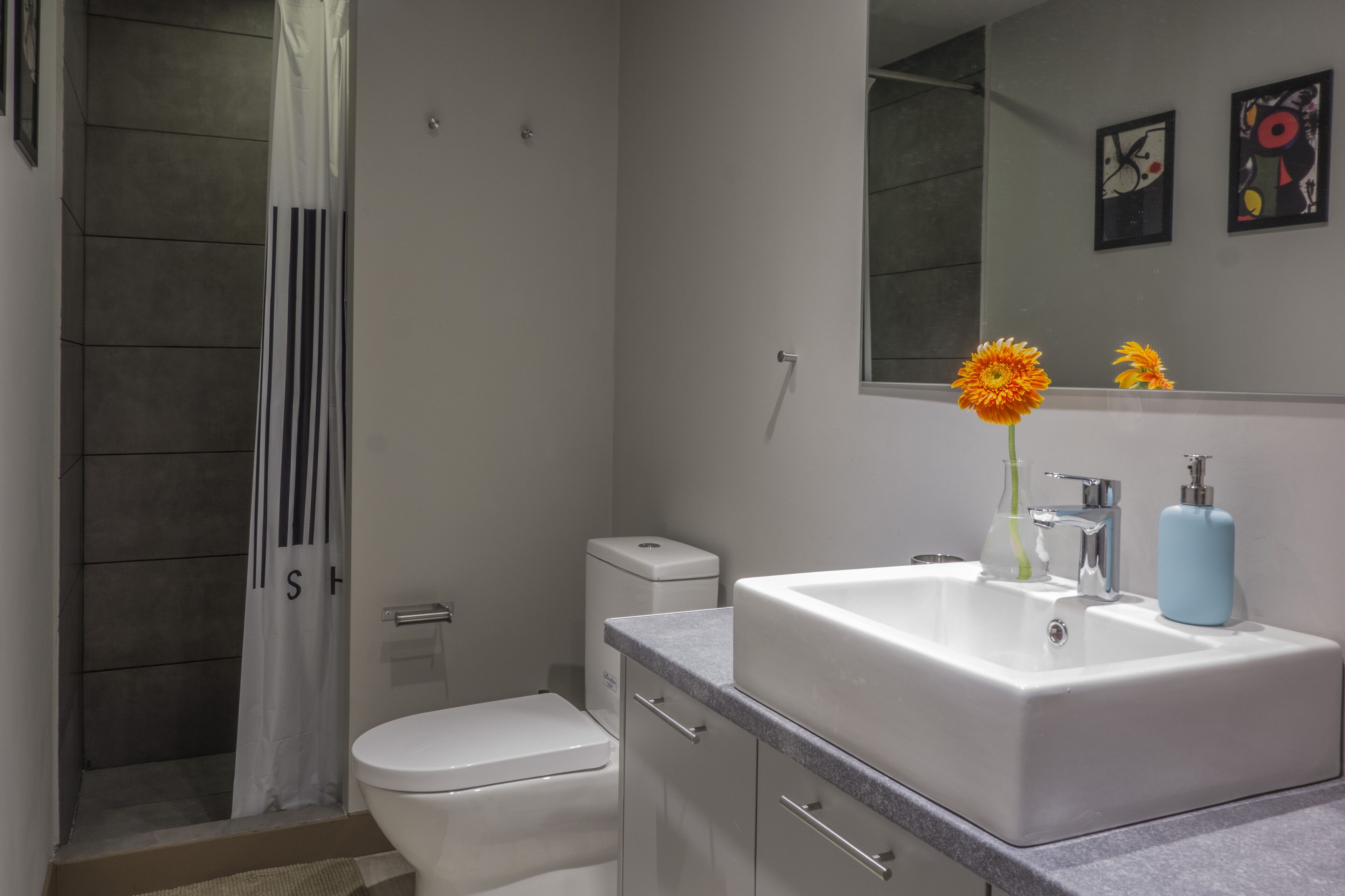 A modern bathroom with a shower, toilet, and sink.