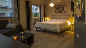Una camera da letto moderna con un letto, un divano, un comodino con una lampada e vista sull'esterno.