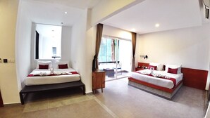 Habitación de hotel con dos camas, un escritorio y un ventanal grande.