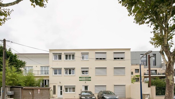 A multi-story residential building with a beige facade, two cars parked in front, and a gated entrance. - Flat 35 sqm - 90, av. Gal de Gaulle and 108 rue du Parc (Clamart)