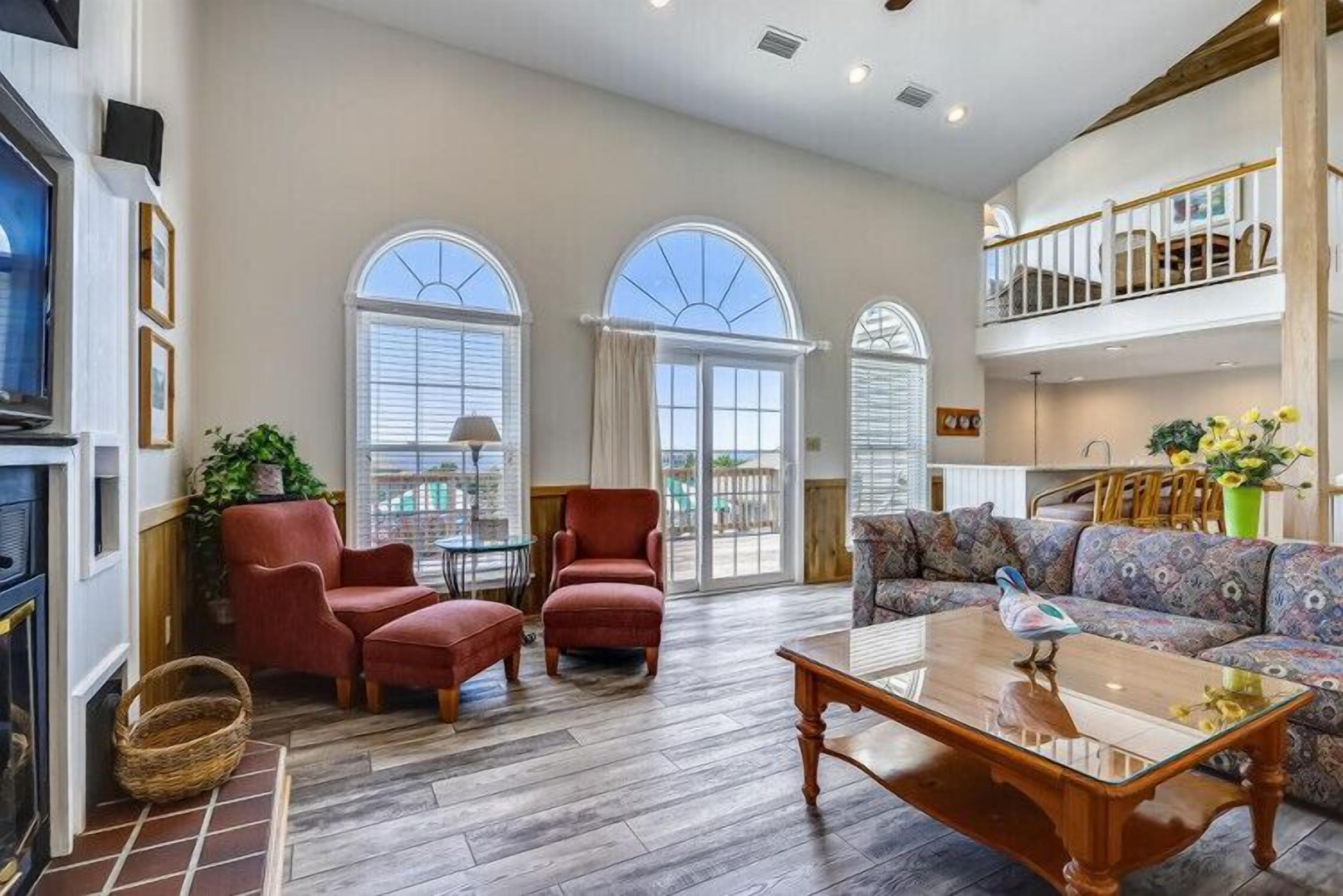 A spacious living room with a fireplace, a sofa set, and a dining area.