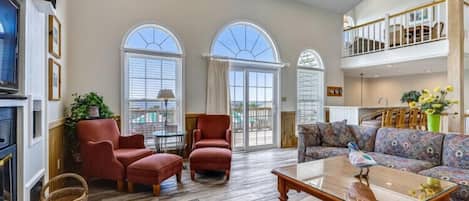 A spacious living room with a fireplace, a sofa set, and a dining area.