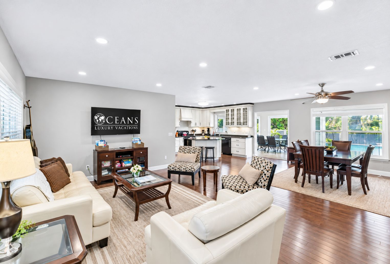 A spacious living area with a dining table, sofas, and a kitchen in the background.