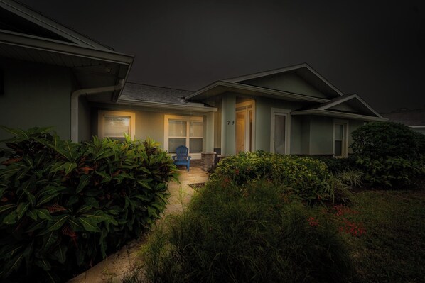A residential house with a well-maintained garden, a front door, and a mailbox. - Whispering Palms - Beach-Side Pool Home (Ponce Inlet)