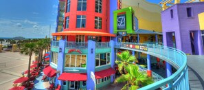 A multi-story building with a balcony, outdoor seating, and a sign for a movie theater.