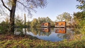 Two wooden floating houses on a calm lake surrounded by trees. - Unique cabin on pond, 2 to 4 ppl, pets allowed (Veauchette)