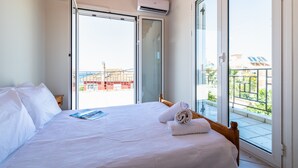 A hotel room with a large bed, a window, and an air conditioning unit. - Beach Front Villa Gousetis (Zakynthos)