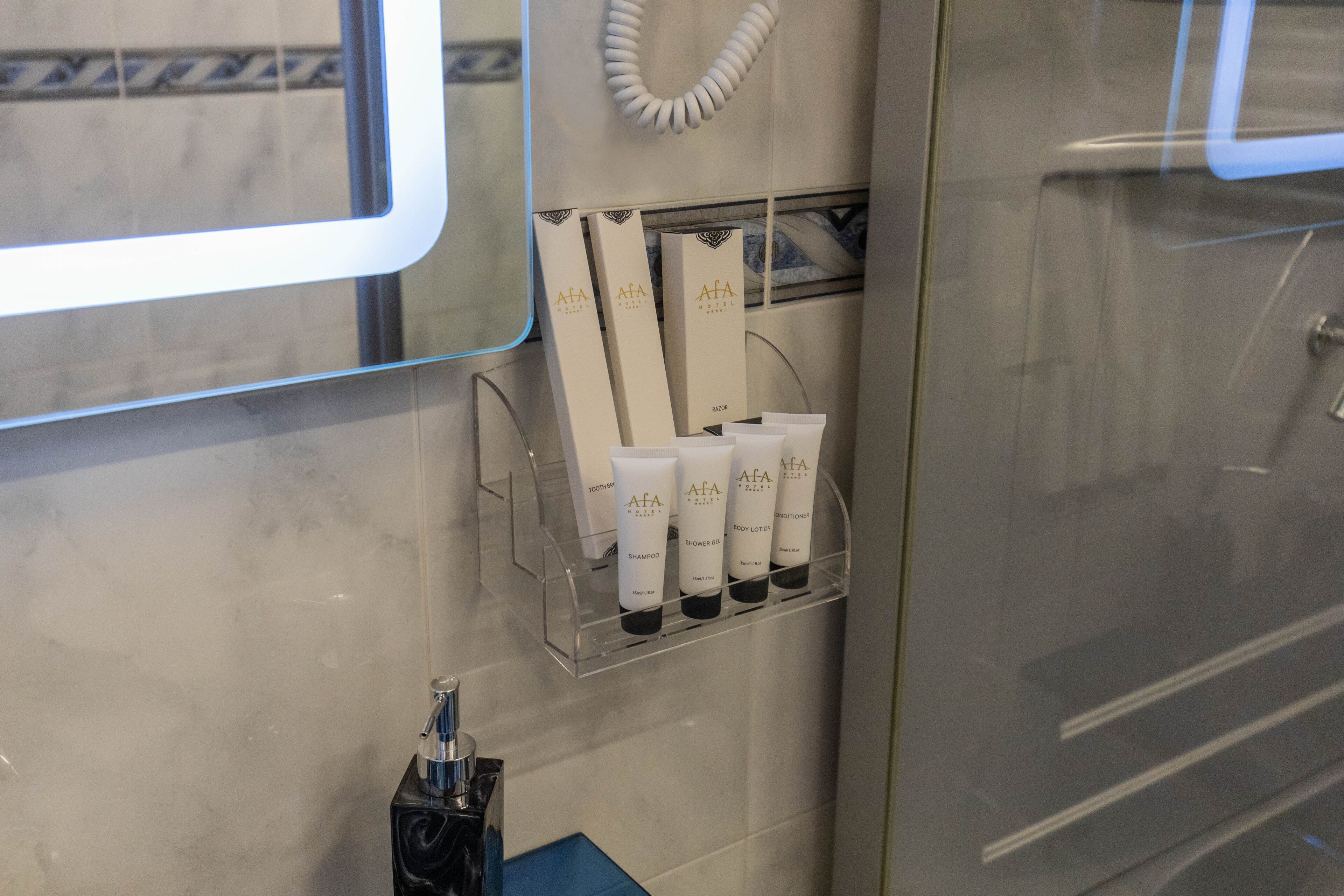 Un baño con un estante despejado para artículos de aseo, un espejo y un perchero.