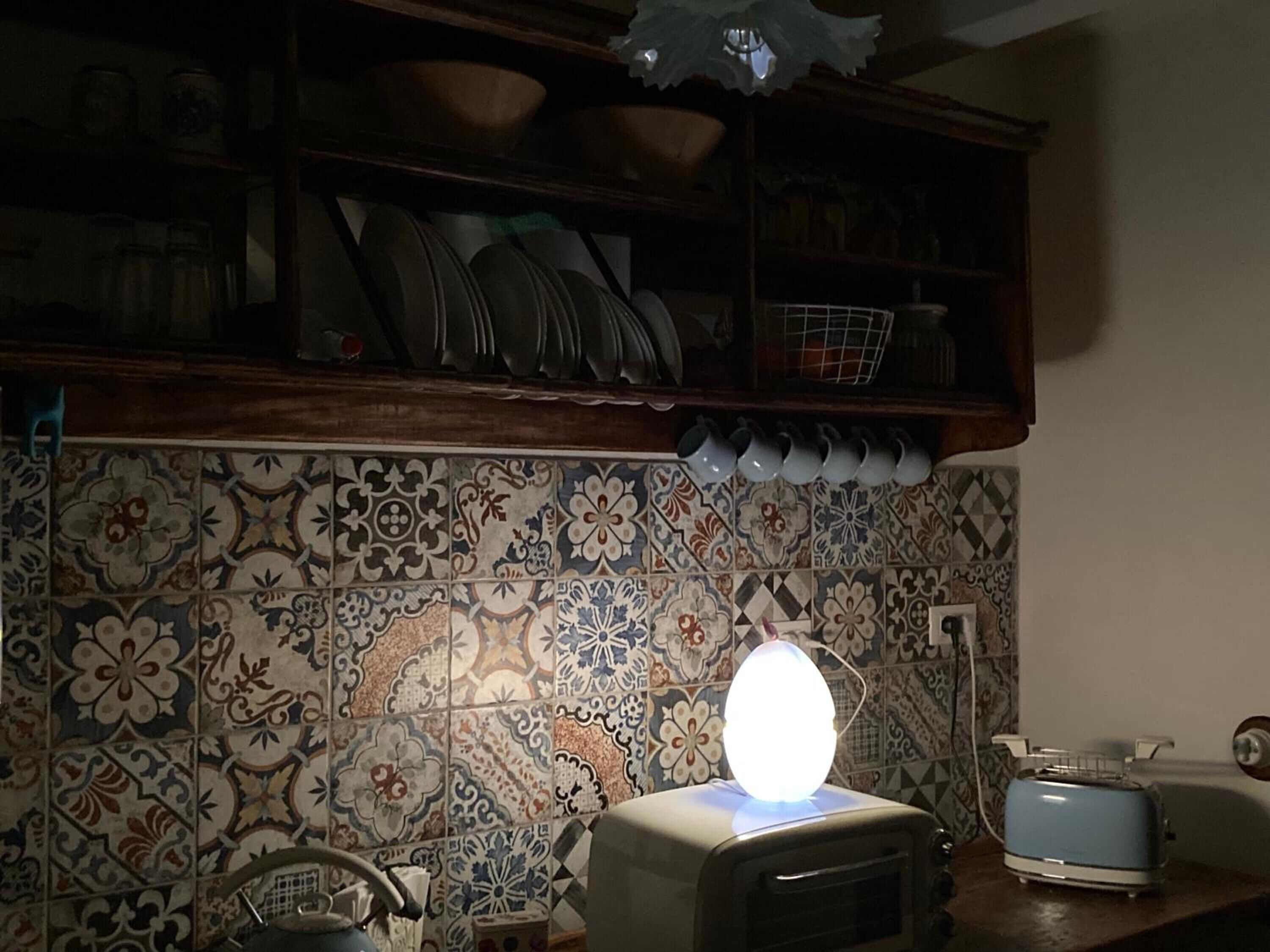 A kitchen with a patterned tile backsplash, a toaster, and a kettle on the counter.