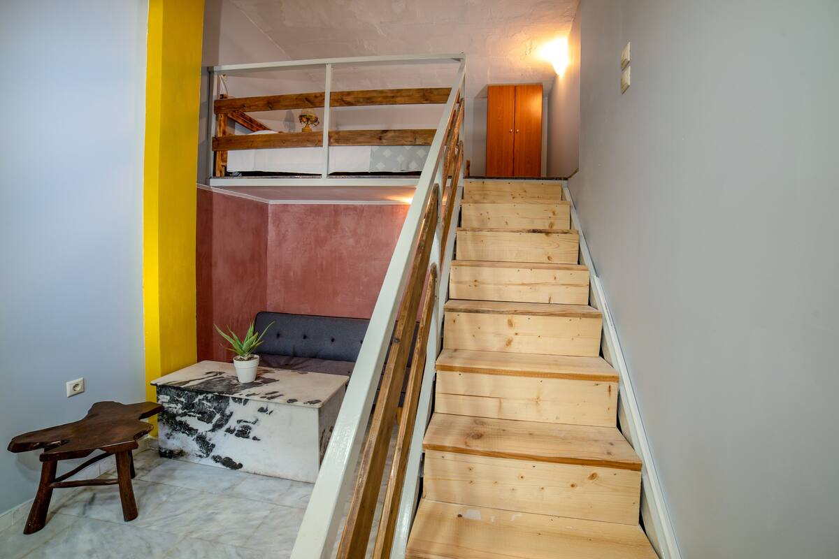 A staircase with wooden steps leading to a loft area.