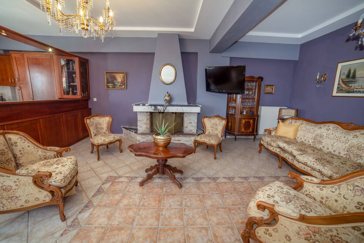 A living room with a fireplace, a television, and a wooden cabinet.