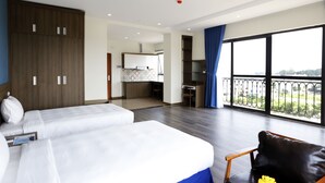 A hotel room with two beds, a kitchenette, a balcony with a view, and a large window. - Minh Quan Building (Vinh Phuc)