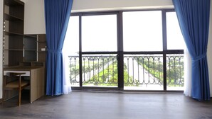 A room with a large window, a wooden desk, and a built-in bookshelf. - Minh Quan Building (Vinh Phuc)