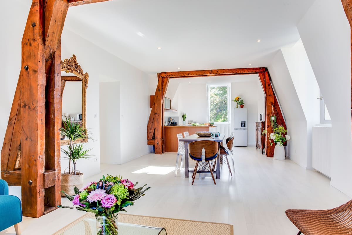 An interior with a dining area, kitchen, and a large mirror.