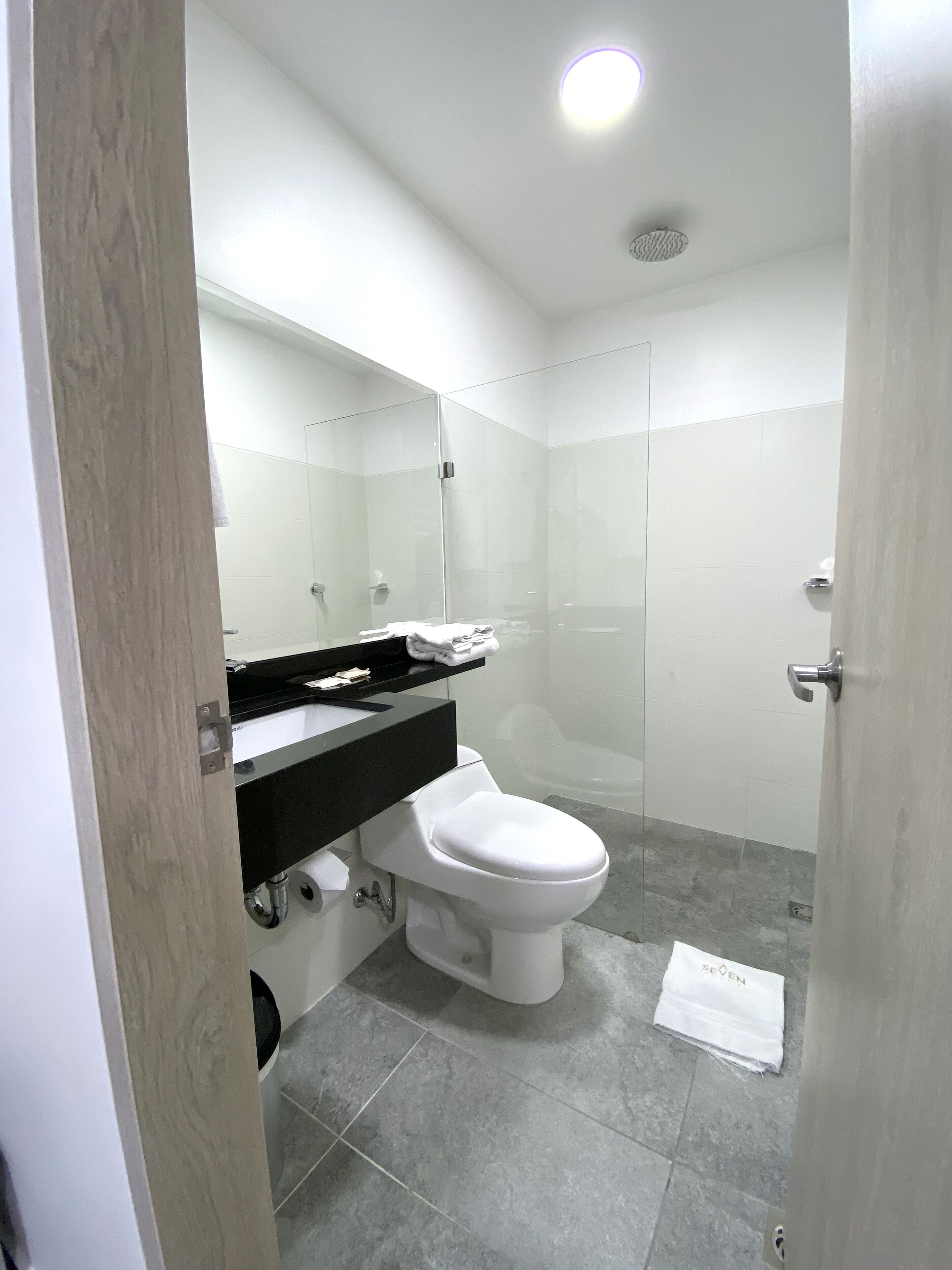 Un baño moderno con inodoro, lavabo y zona de ducha.