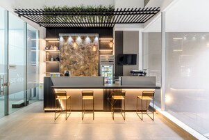 Una cocina moderna con barra, electrodomésticos integrados y un televisor de pantalla plana.
