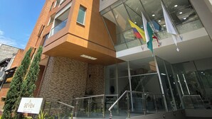 Ein modernes Hotel mit einem einzigartigen architektonischen Design, gekennzeichnet durch eine markante Glasfassade und eine Treppe zum Eingang.