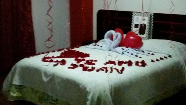 A room with a bed, red heart-shaped balloons, and a heart-shaped decoration on the bed. - Hostal El Parque (Huancayo)