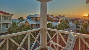 A balcony with a view of a coastal residential area during sunset.