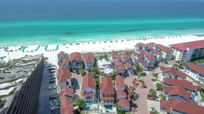 Zona residencial costera con propiedades frente al mar, una carretera y un estacionamiento.