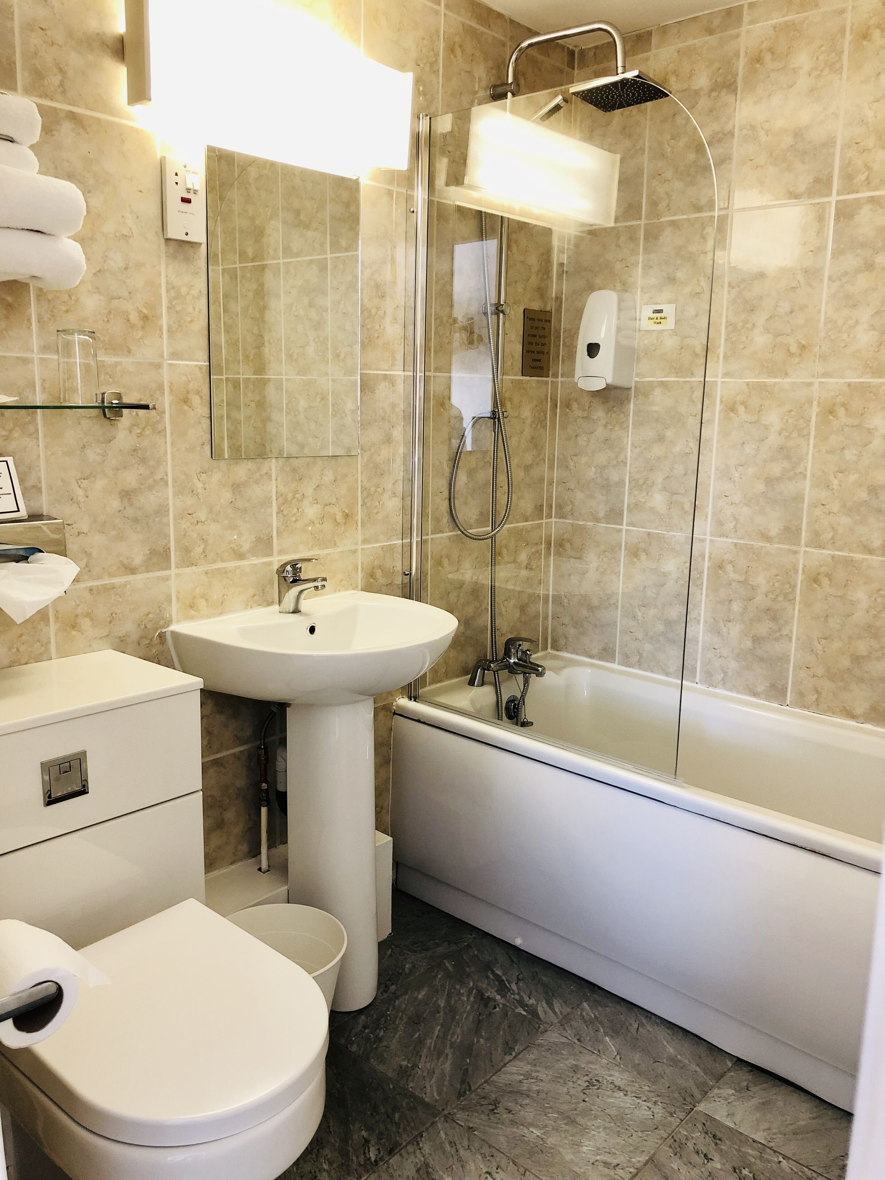 A modern bathroom with a toilet, sink, and bathtub.