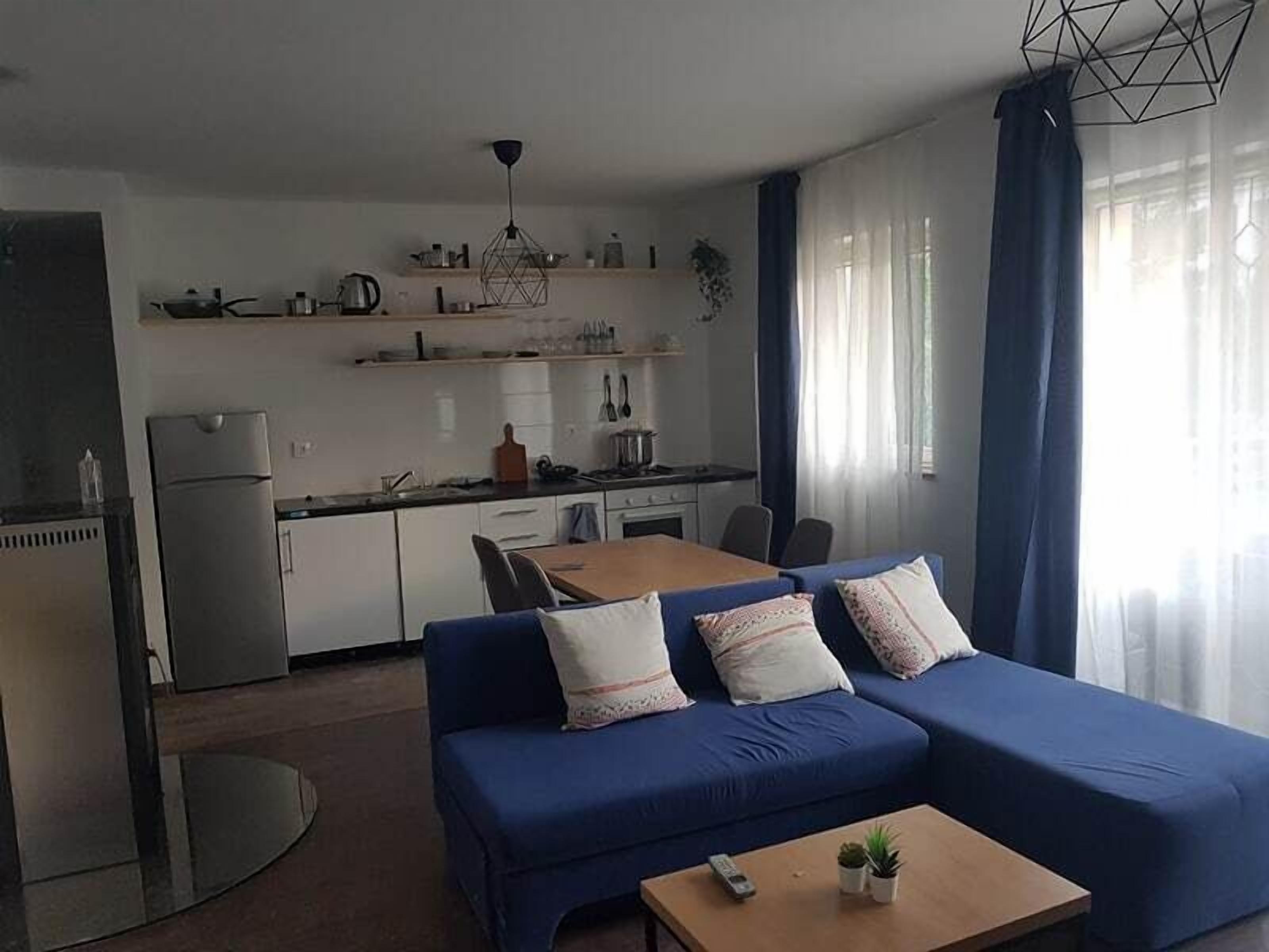 A compact living space with a kitchenette, a sofa set, a dining table, and a coffee table. - Anica Apartmani (Funtana)