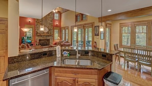A spacious kitchen with granite countertops, a built-in dishwasher, and a large island with a sink. - A Foxfire Retreat: Gated Resort w/ Pools & Hot Tub, Fishing, Fitness Area (Boone)
