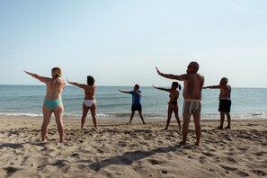 A group of people on a sandy beach with the ocean in the background. - Hotel Adria (Alba Adriatica)