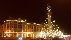 Un hôtel doté d’une tour imposante et agrémenté de décorations florales illuminées.