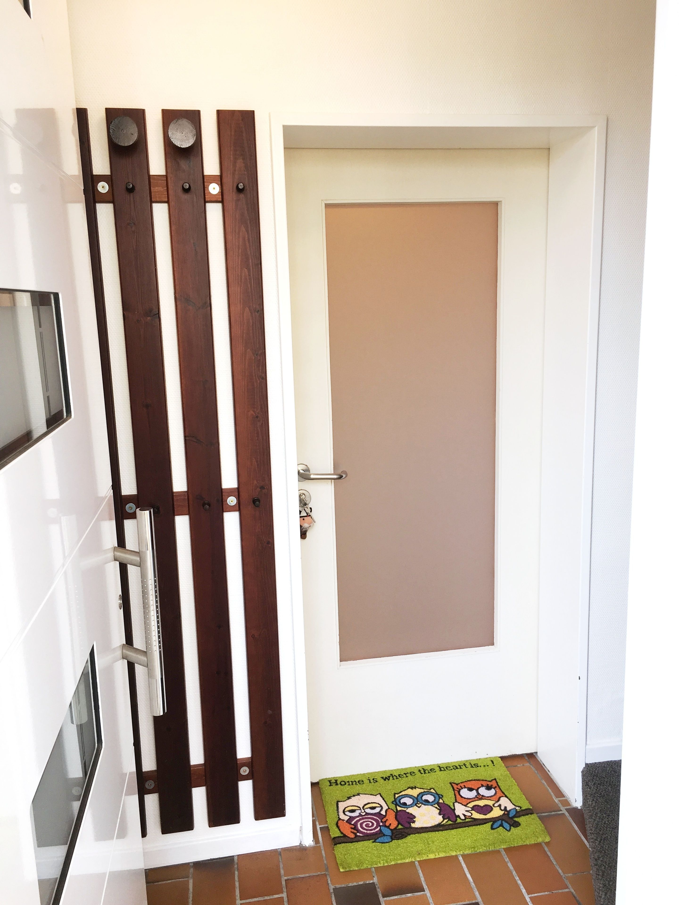 Una porta con pannello verticale marrone e un tappetino davanti alla porta con personaggi dei cartoni animati.