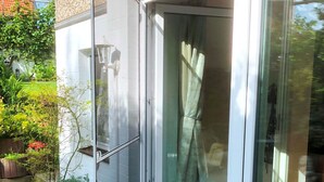 A modern house with a sliding glass door leading to a red carpeted entrance. - Ferienwohnung Dettum (Dettum)