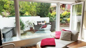 A modern living room with a large sliding glass door leading to a patio area. - Ferienwohnung Dettum (Dettum)