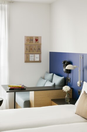 A neatly arranged bedroom with a bed, bedside table, lamp, and a wall-mounted phone. - Oh La La! Hotel bar - Paris Bastille (Paris)