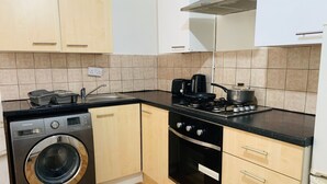 Una cocina compacta equipada con lavadora, estufa y lavaplatos.