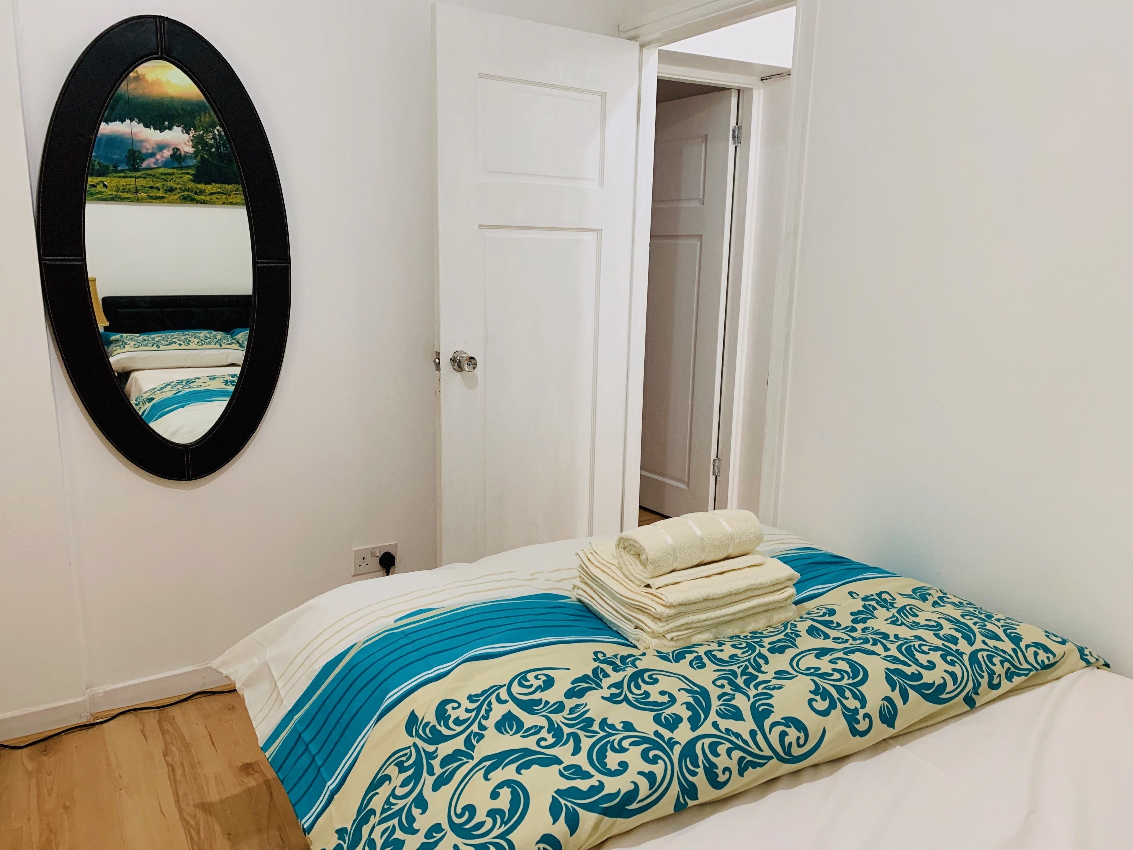 A bedroom with a bed, a mirror, and a door leading to a closet.